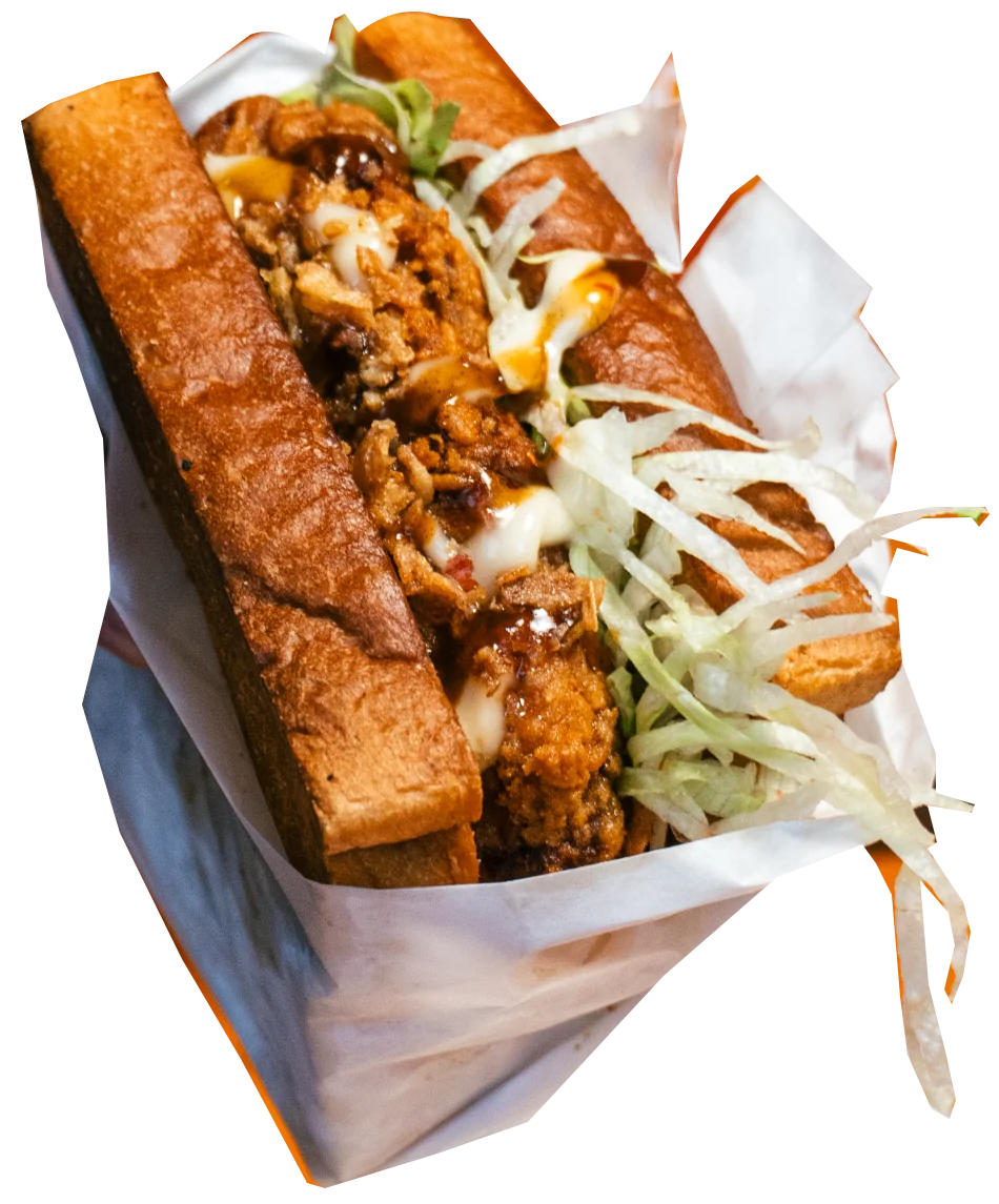 Nippon fried chicken sando with sauce, lettuce and crispy onions in its wrapper